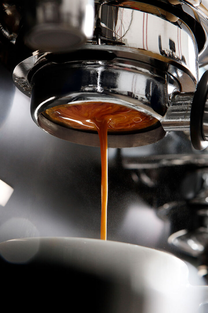 A close up of an espresso machine pouring liquid.