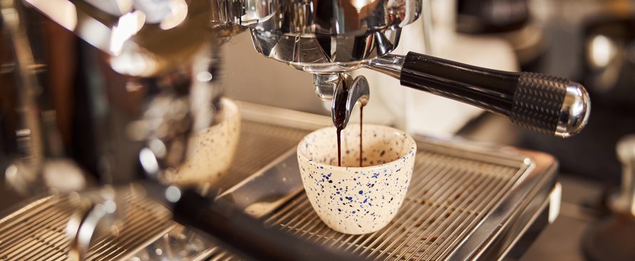Clean modern espresso machine and freshly made coffee