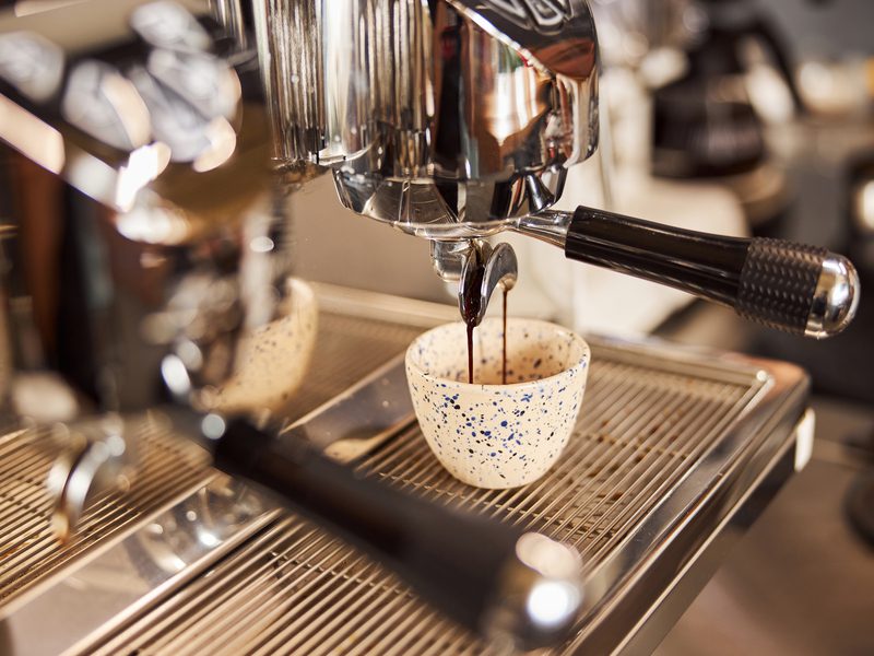Clean modern espresso machine and freshly made coffee